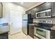 Functional kitchen featuring stainless steel appliances, dark cabinetry, and durable granite countertops at 5345 E Van Buren St # 305, Phoenix, AZ 85008