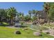 Serene pond featuring a small waterfall, surrounded by lush greenery and mature palm trees at 5345 E Van Buren St # 305, Phoenix, AZ 85008