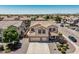 Detailed aerial view of a beige home featuring a tile roof, a spacious driveway, and meticulously manicured landscaping at 551 E Sun Valley Farms Ln, San Tan Valley, AZ 85140