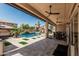 Backyard view showcasing the pool area, covered patio, and manicured landscaping, creating a perfect outdoor oasis at 551 E Sun Valley Farms Ln, San Tan Valley, AZ 85140