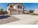 View of the front of the house, showcasing the large driveway and desert landscaping at 551 E Sun Valley Farms Ln, San Tan Valley, AZ 85140
