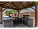Outdoor kitchen with concrete countertops and built-in grill, a perfect space for entertaining Gathering and friends at 551 E Sun Valley Farms Ln, San Tan Valley, AZ 85140