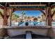 View of the inviting pool area from the gazebo, complete with lounge chairs, an umbrella, and lush landscaping at 551 E Sun Valley Farms Ln, San Tan Valley, AZ 85140