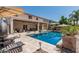 Inviting backyard pool area featuring lush landscaping, a covered patio, gazebo, and comfortable lounge furniture for relaxation at 551 E Sun Valley Farms Ln, San Tan Valley, AZ 85140