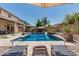 Relaxing poolside with lounge chairs, shaded cabana, waterfall feature, and blue swimming pool at 551 E Sun Valley Farms Ln, San Tan Valley, AZ 85140