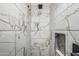 Modern shower featuring marble-look tiling and built in niche at 551 E Sun Valley Farms Ln, San Tan Valley, AZ 85140