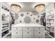 Spacious walk-in closet features custom shelving, storage and decorative light fixtures at 551 E Sun Valley Farms Ln, San Tan Valley, AZ 85140