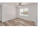 A bright bedroom with a ceiling fan, window with blinds, and wood-look flooring at 5721 W Palo Verde Ave, Glendale, AZ 85302