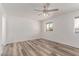 Neutral bedroom featuring a ceiling fan, window with blinds, and vinyl flooring at 5721 W Palo Verde Ave, Glendale, AZ 85302