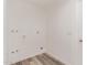 Clean and functional laundry area with bright white walls and wood-look flooring at 5721 W Palo Verde Ave, Glendale, AZ 85302