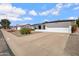 View of the charming white house showing a two-car garage, trimmed bushes, and a gravel yard at 635 N 67Th Pl, Mesa, AZ 85205