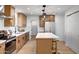 Modern kitchen features wood cabinetry, stainless steel appliances, white countertops, and a stylish island with seating at 635 N 67Th Pl, Mesa, AZ 85205