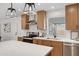 This modern kitchen boasts wood cabinets, white countertops, stainless appliances, and updated fixtures at 635 N 67Th Pl, Mesa, AZ 85205