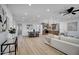 Sun-filled open-concept living space with hardwood floors, neutral decor, and smooth transitions to the dining area at 635 N 67Th Pl, Mesa, AZ 85205