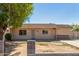 Single story home with a security door and tan colored paint surrounded by a tree and green grass at 649 S Temple St, Mesa, AZ 85204