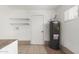 Utility room with water heater, shelving, and neutral tiling at 649 S Temple St, Mesa, AZ 85204