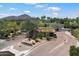 Exclusive gated entrance with desert landscaping, mature trees, and mountain views create inviting curb appeal at 6624 N 66Th N Pl, Paradise Valley, AZ 85253