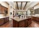 Gourmet kitchen featuring a large island with sink, custom cabinets, hardwood floors, and stainless steel appliances at 6624 N 66Th N Pl, Paradise Valley, AZ 85253