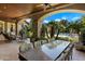 Spacious covered patio with stone columns and a large dining table overlooking the pool and landscaped yard at 6624 N 66Th N Pl, Paradise Valley, AZ 85253