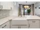 Bright kitchen with a farmhouse sink, white cabinets, and a view to the outdoor patio at 7222 E Gainey Ranch Rd # 241, Scottsdale, AZ 85258