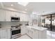 Bright kitchen with white cabinets, modern appliances, and a sliding door to the balcony at 7222 E Gainey Ranch Rd # 241, Scottsdale, AZ 85258