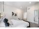 Spacious bedroom with large bed, modern chandelier, and adjacent bathroom at 7222 E Gainey Ranch Rd # 241, Scottsdale, AZ 85258