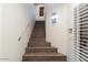 Contemporary staircase with wood treads, a metal handrail, and a modern sconce at 7222 E Gainey Ranch Rd # 241, Scottsdale, AZ 85258