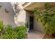 Charming home entrance featuring a covered porch, lush greenery, and a secure gate for added privacy at 7710 E Gainey Ranch Rd # 142, Scottsdale, AZ 85258