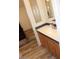 A bathroom vanity with a sink, cabinets, decorative mirror, and wood-look flooring at 7807 E Main St # G-23, Mesa, AZ 85207