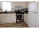 Cozy kitchen features white cabinets, stainless steel appliances and laminate flooring at 7807 E Main St # G-23, Mesa, AZ 85207