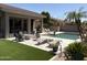 Lush backyard featuring a pristine pool, well-manicured lawn, and relaxing lounge area at 7940 E Quill Ln, Scottsdale, AZ 85255