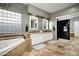 Well-lit bathroom with a soaking tub, double vanity, and walk-in closet access at 7940 E Quill Ln, Scottsdale, AZ 85255