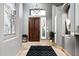 Grand foyer features a chandelier, tile flooring, a wooden front door, and modern decor at 7940 E Quill Ln, Scottsdale, AZ 85255