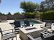 Backyard pool area with chairs, sun loungers and a modern fire pit with glass rocks at 7940 E Quill Ln, Scottsdale, AZ 85255
