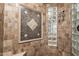 Close up on walk-in shower showcasing designer tile work and a glass block accent window at 7940 E Quill Ln, Scottsdale, AZ 85255