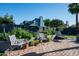Backyard with brick patio, seating, garden beds, and a tall privacy fence at 8037 E Krail St, Scottsdale, AZ 85250