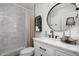Well-lit bathroom featuring modern vanity, oval mirror, tiled shower, and stylish decorative elements at 8037 E Krail St, Scottsdale, AZ 85250