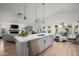 Open-concept kitchen featuring a large island with quartz countertops, stainless steel appliances, and modern pendant lighting at 8037 E Krail St, Scottsdale, AZ 85250