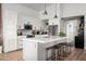 Bright kitchen featuring a large island with seating, stainless steel appliances, white cabinets, and modern pendant lights at 8037 E Krail St, Scottsdale, AZ 85250
