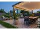 Inviting outdoor patio with a dining table and chairs under a covered pergola, surrounded by lush greenery at 8037 E Krail St, Scottsdale, AZ 85250