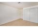 A bedroom with tile flooring, white walls, closet doors, and a door to another room at 8101 E 4Th Ave, Mesa, AZ 85208