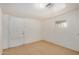 A bedroom with tile flooring, a window with blinds, and a closed door to the outside at 8101 E 4Th Ave, Mesa, AZ 85208