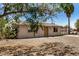 Exterior shot of single-story house with gravel yard and mature landscaping providing shade and curb appeal at 8101 E 4Th Ave, Mesa, AZ 85208