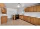 Kitchen with tiled floor, wooden cabinets, modern appliances, and a window offering natural light at 8101 E 4Th Ave, Mesa, AZ 85208
