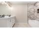 Modern bathroom with a double sink vanity, decorative light fixture, and a soaking tub with tiled shower at 8124 N 45Th Ave, Glendale, AZ 85302