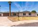 Inviting single-level home with a tidy yard, long driveway, and a prominent palm tree at 8124 N 45Th Ave, Glendale, AZ 85302