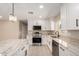 Modern kitchen featuring white cabinets, granite countertops, stainless steel appliances, and contemporary lighting at 8124 N 45Th Ave, Glendale, AZ 85302