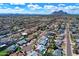 Expansive aerial view capturing a neighborhood's lush landscapes, blue pools, and scenic mountain backdrop in the distance at 8326 E Valley View Rd, Scottsdale, AZ 85250