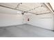 Spacious two-car garage with an automatic door opener, overhead lighting, and painted walls at 8326 E Valley View Rd, Scottsdale, AZ 85250