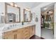 Bright bathroom features a double sink vanity with modern lighting and a peek into a large walk-in closet at 8931 W Alex Ave, Peoria, AZ 85382